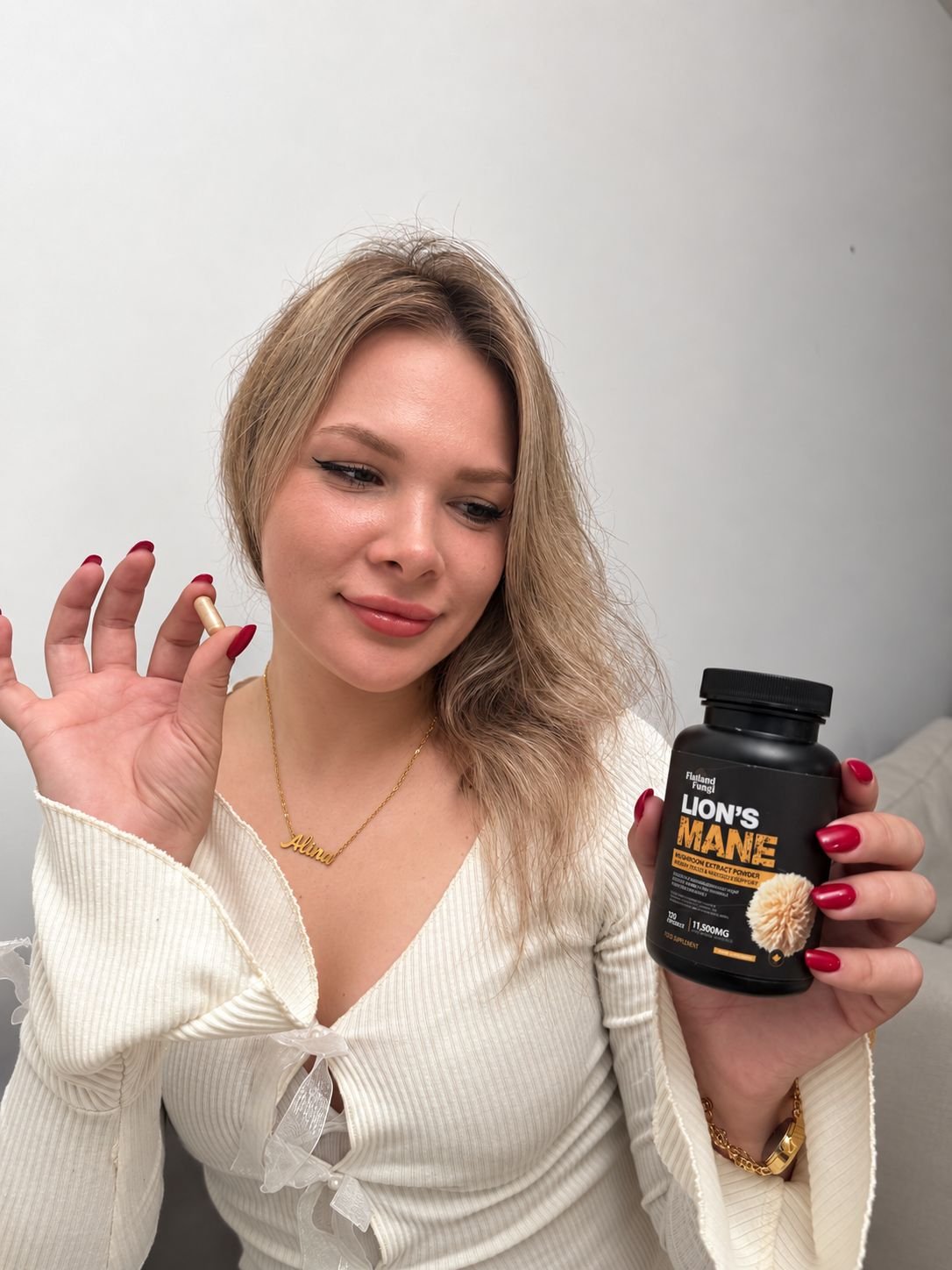 Alina holding a Lion's Mane capsule and a bottle of Flatland Fungi Lion's Mane